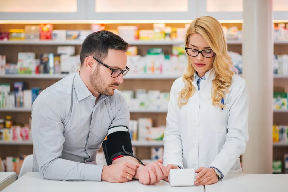 Pharmacist monitoring customer’s blood pressure at Kingsland Pharmacy, Mary Street, Southampton.