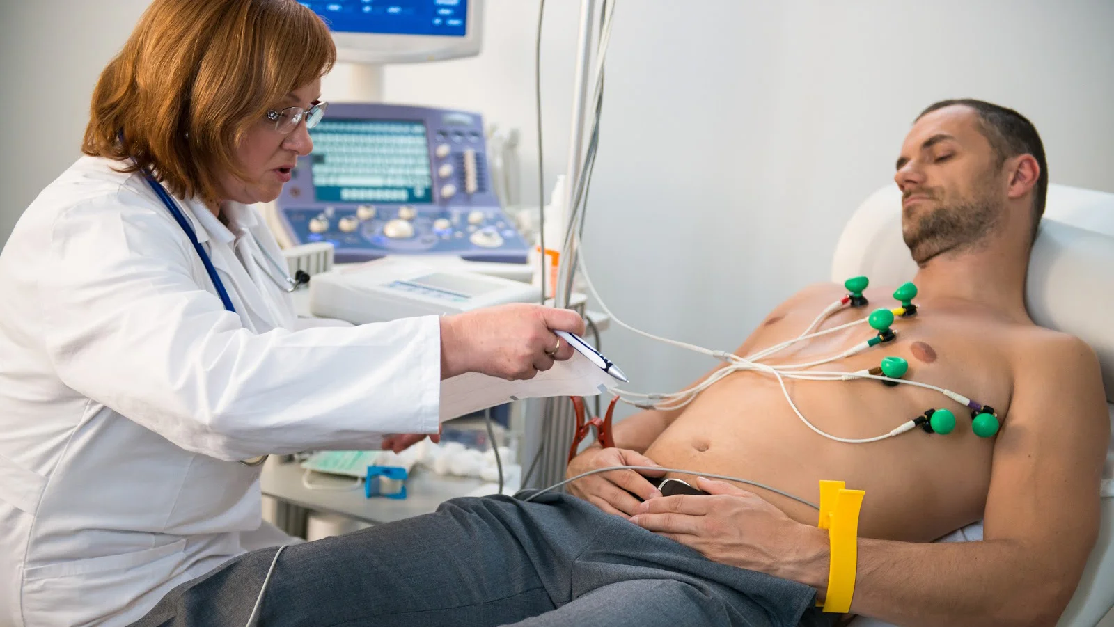 Patient undergoing ECG test with electrode sensors attached to chest.