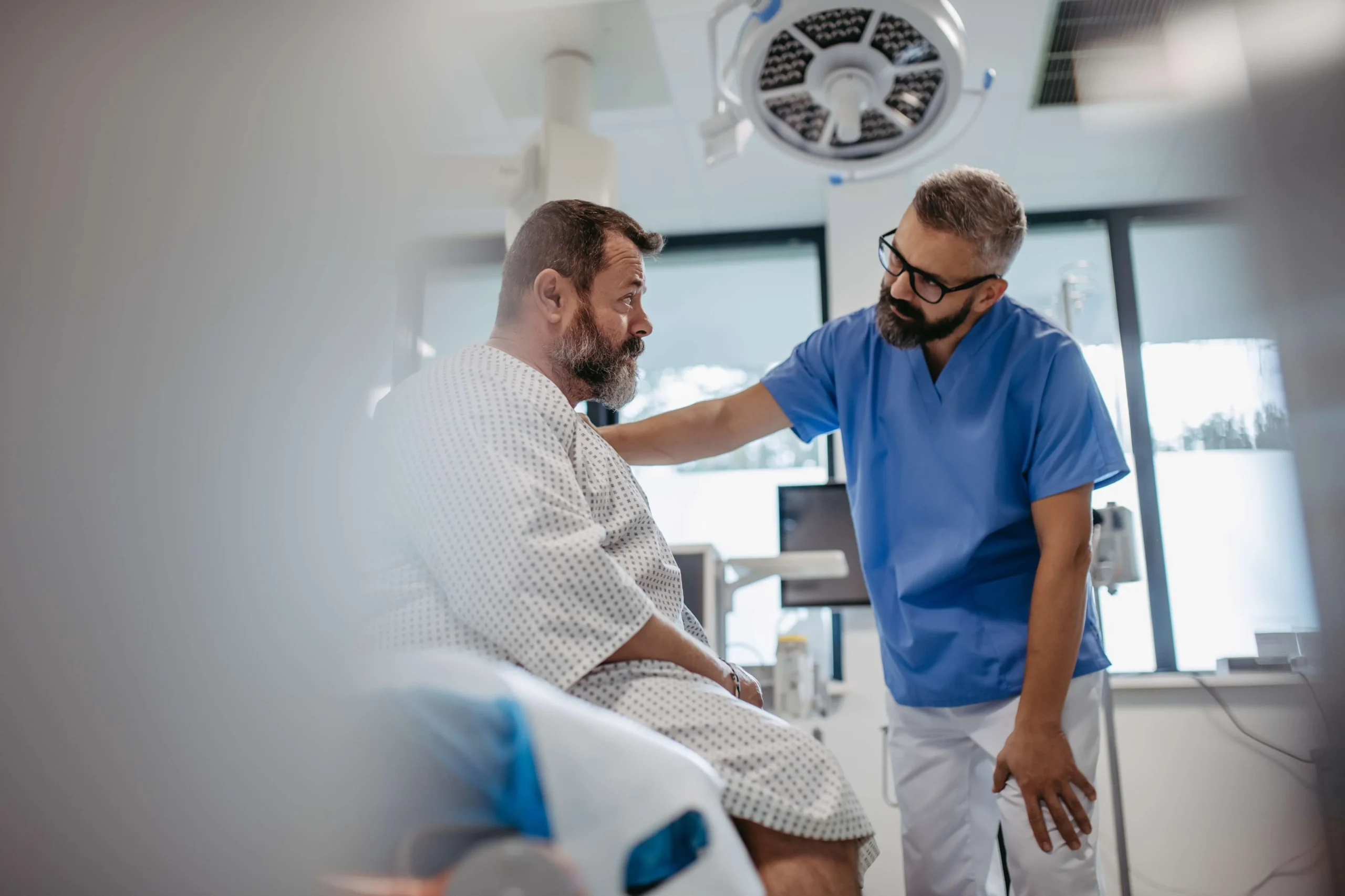 Healthcare professional supporting patient during consultation in a clinical setting.
